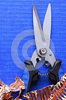 Snip Cutter and Copper Scrap on blue background