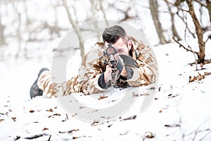 Sniper aiming through scope and shooting with rifle during operation - war concept or hunting concept