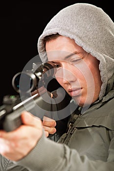 Sniper in hood aims at rifle photo