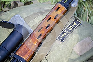 Sniper rifle with wooden fore end laying on tactical backpack.