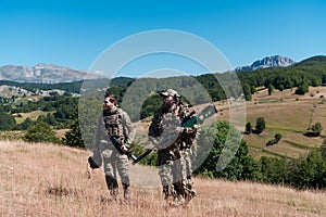 A sniper team squad of soldiers is going undercover. Sniper assistant and team leader walking and aiming in nature with