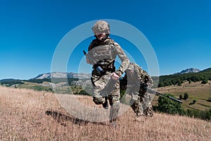 A sniper team squad of soldiers is going undercover. Sniper assistant and team leader walking and aiming in nature with