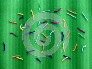 Snips of colorful threads on green background