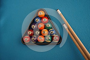 Snooker balls and cue on blue background. Billiard balls on the board. Pool table with rack of balls