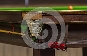 Snooker balls scored in the hole, the light in the hole, the background close-up