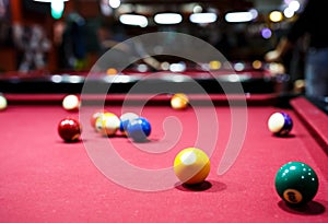 Snooker multicolored balls lay as a pyramid on the table. Closeup view. Billiard red table with cue and balls. Leisure, hobby,