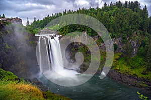 Snoqualmie Falls with lush greenery and mist in Washington State, USA