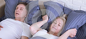 Snoring man. Couple in bed, man snoring and woman can not sleep, covering ears with pillow for snore noise. Middle age