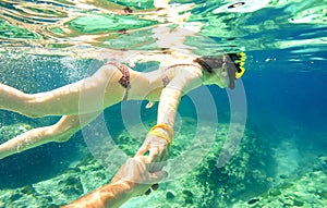 Snorkel couple swimming together in tropical sea underwater