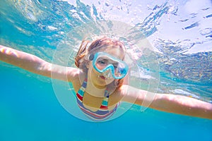 Snorkeling blond kid girl underwater goggles and swimsuit