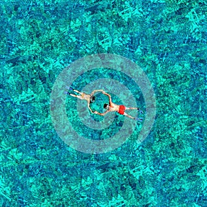 Snorkeling couple in the sea water. View from a drone