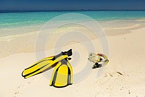 Snorkeling equipment mask, snorkel and fins on sand at beach