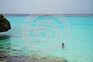 snorkeling girl looking at the crystal clear blue sea