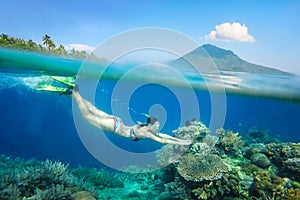 Snorkeling woman above the beatiful coral reef