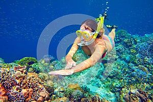 Snorkeling woman above the vivid coral reef