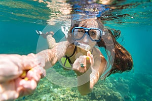 Snorkelling woman makes tempting gesture in ocean
