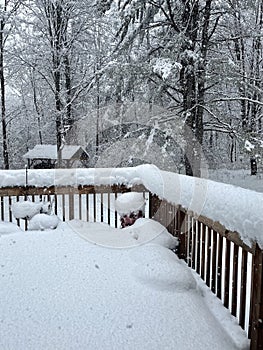 Snow accumulating on a wood deck during Noreaster photo