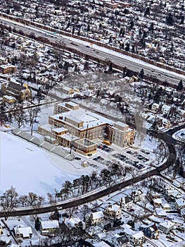 Snow art: Aerial view city blanketed with snow in winter  covering recreational area and municipal building in the foreground.