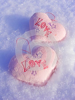 Snow background with two pink hearts love