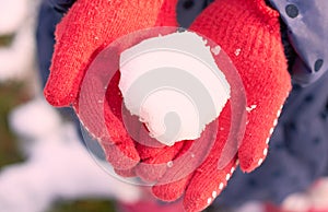 A snow ball in the hands of a child