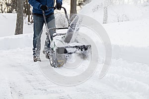 Snow blower in action clearing a residential driveway after snow storm