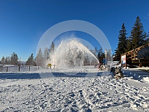 Snow blower in a ski resort on a sunny winter day