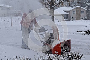 Snow blowing a driveway on a blustery winter day