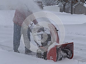 Snow blowing a driveway on a blustery winter day