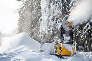 Snow cannon gun or machine sprays water and snowes a ski or cross-country track