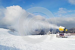 Snow cannon machine blowing artificial snow on Azuga ski domain, Prahova Valley region, Romania, during the Winter low season.