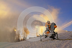 Snow cannon prepares ski slope early in the morning