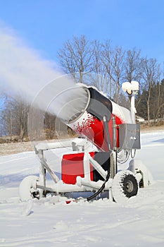 Snow cannon on ski slope in action