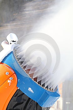 Snow cannon on ski slope in action