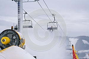Snow cannon throwing Producting Snowon slope, snowmaker in action at ski resort