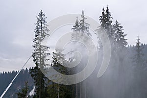 Snow cannon throwing Producting Snowon slope, snowmaker in action at ski resort