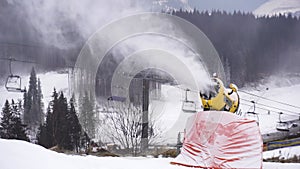 Snow cannon throwing Producting Snowon slope, snowmaker in action at ski resort