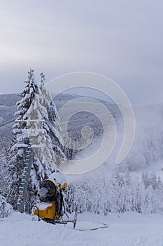 Snow cannon in winter landscape