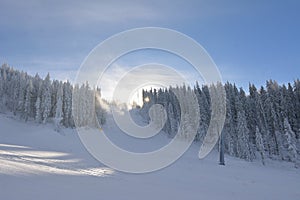 Snow cannons making artificial snow on a ski slope in Poiana Brasov