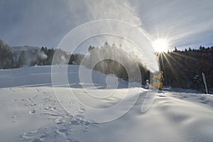 Snow cannons making artificial snow on a ski slope in Poiana Brasov