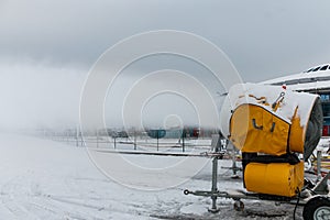 Snow cannons spray artificial snow crystals. Production of artificial snow. Cars make snow