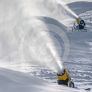 Snow cannons spraying artificial snow in winter
