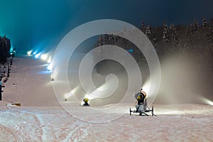 Snow cannons working at night in the mountains