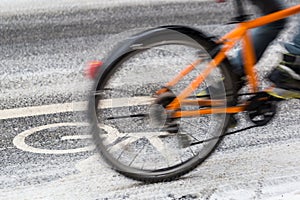 A snow-capped bike path and a partial view of a cyclist