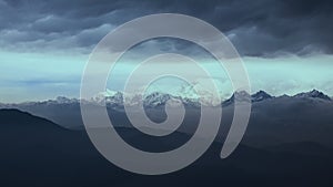 Snow capped mountain in Darjeeling India with sunrise colours and moody clouds