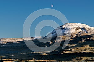 Snow capped mountain with the moon