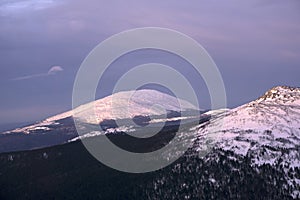 Snow-capped mountain peaks illuminated by the low morning sun