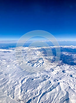 Snow capped mountain range against blue skies