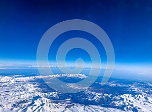 Snow capped mountain range against blue skies