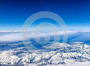 Snow capped mountain range against blue skies