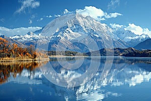 A snow-capped mountain reflected in a crystal-clear lake